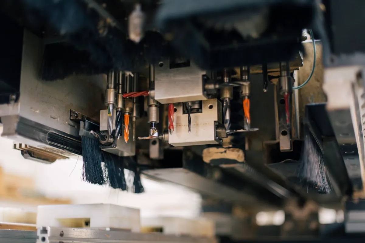 Close-up of an automated production machine with tooling and brushes